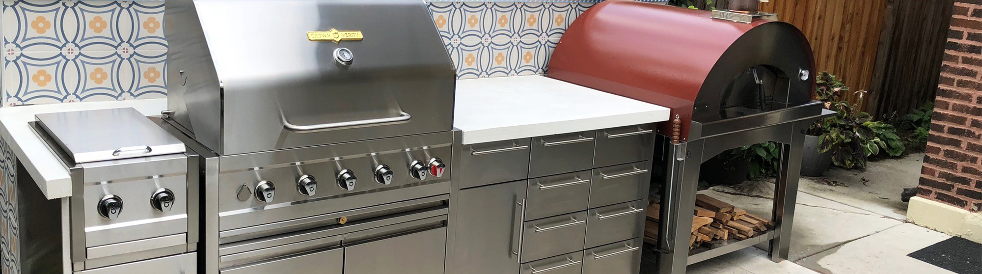 Stainless steel pull out drawers for outdoor kitchen with bbq and backsplash.